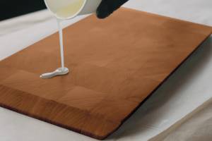 mineral oil being poured onto a cutting board